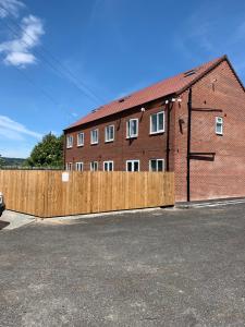 a brick building with a wooden fence in front of it at Campion Place Contractor Accommodation in Sheffield