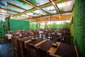 a restaurant with tables and chairs and a green wall at Hotel Hangout in Pune