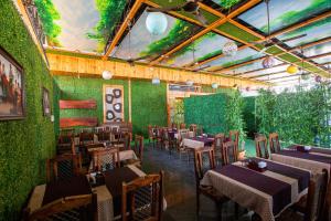 a restaurant with tables and chairs and a green wall at Hotel Hangout in Pune