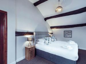 a bedroom with a bed and a night stand with a lamp at Stable End Cottage in Bouth