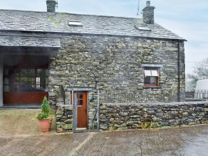 an old stone house with a door and a window at Stable End Cottage in Bouth