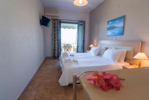 - une chambre avec un lit et une table fleurie dans l'établissement Spiti Marias by Thanos Village, à Gialova