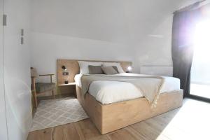 ein Schlafzimmer mit einem großen Bett mit einem Holzrahmen in der Unterkunft VIlla Luka - new isolated villa with heated pool, jacuzi and sauna in Gračac