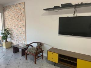 瓜魯柳斯的住宿－Pousada Internacional EAS Airport 10min，客厅设有壁挂式平面电视。