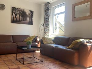 a living room with a couch and a table at Quiet holiday home in Valkenburg in Valkenburg