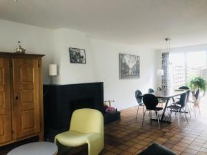een woonkamer met een tafel en stoelen en een open haard bij Quiet holiday home in Valkenburg in Valkenburg