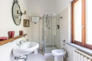 a white bathroom with a sink and a shower at Abadia Farneto in Gubbio