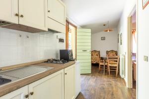 a kitchen with white cabinets and a table with chairs at Abadia Farneto in Gubbio