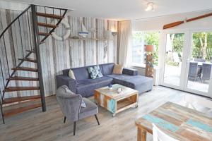 a living room with a blue couch and a table at Vakantiehuis Grevelingen 12 aan Grevelingenmeer. nabij Port Greve in Brouwershaven