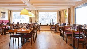 een eetkamer met houten tafels en stoelen bij Rhein Hotel Bacharach in Bacharach