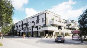 a large white building with a car parked in front of it at Apartament centrum in Ciechocinek