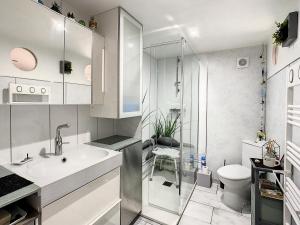 ein weißes Bad mit einem Waschbecken und einem WC in der Unterkunft Neptune in Royan