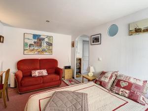 ein Schlafzimmer mit einem roten Sofa und einem Bett in der Unterkunft Neptune in Royan