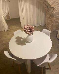 einen weißen Tisch mit einer Vase mit einer Blume darauf in der Unterkunft La casa di Alessia Largo Torre in Noci