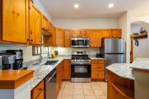 a kitchen with wooden cabinets and stainless steel appliances at 8782 Trappers Crossing Condo in Keystone