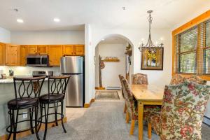 a kitchen and dining room with a wooden table and chairs at 8782 Trappers Crossing Condo in Keystone
