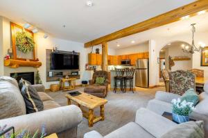 a living room with couches and a kitchen at 8782 Trappers Crossing Condo in Keystone
