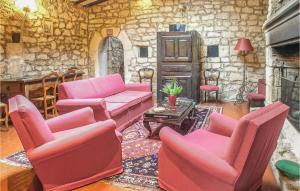 a living room with pink furniture and a stone wall at Stunning Home In Cézac in Cézac