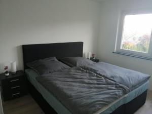 a bed in a bedroom with a large window at Haus Hochwald in Rottweil