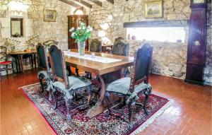 a dining room with a table and chairs on a rug at Amazing Home In Czac With Outdoor Swimming Pool in Marcamps