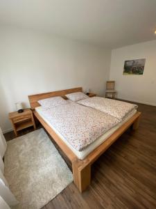 een groot bed in een kamer met een houten vloer bij Schwarzwaldidyll in Todtmoos