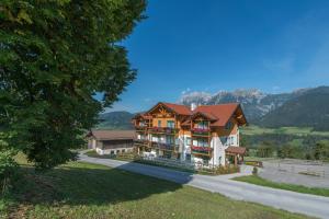 a large house with mountains in the background at Landhaus Birgit in Haus im Ennstal