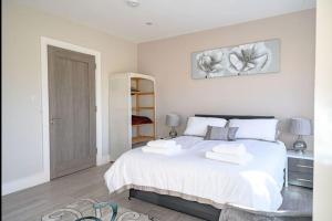 sypialnia z białym łóżkiem i 2 ręcznikami w obiekcie No 1 Kinvara House w Killarney