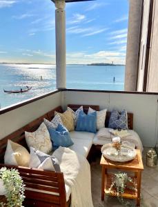 a balcony with a couch and a view of the water at Lagoon Secret Venice in Venice