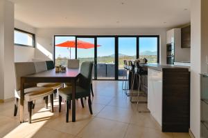 cocina y comedor con mesa y sillas en Villa à l'entrée de Porticcio - Piscine - Vue dégagée, en Cauro