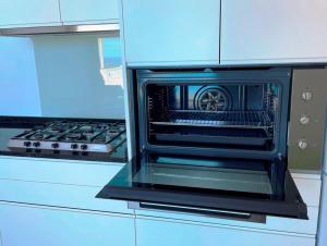 an oven with its door open in a kitchen at Villa Escola da Bica in Arco da Calheta