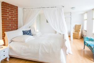 a white bed in a room with a brick wall at Ferienhaus Fischerglück im Herzen von Plau am See in Plau am See