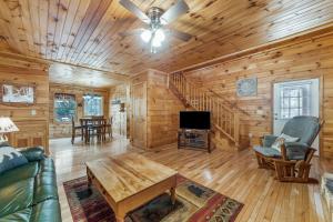a log cabin living room with a couch and a tv at Rocky Road Retreat in Ellijay