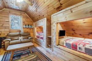 a log cabin bedroom with a bed and a tv at Rocky Road Retreat in Ellijay