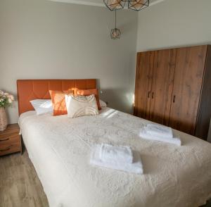 ein Schlafzimmer mit einem großen Bett mit zwei Handtüchern darauf in der Unterkunft HOMER in Ágios Athanásios