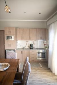 uma cozinha com armários de madeira e uma mesa com cadeiras em HOMER em Áyios Athanásios