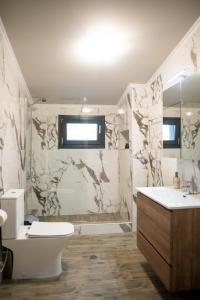 a bathroom with a toilet and a sink and a tub at HOMER in Áyios Athanásios