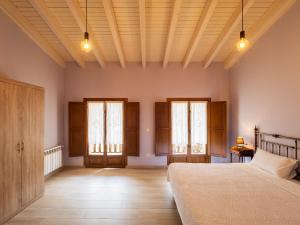 a bedroom with a bed and two windows at Casa Rural Picu Llagos in Cangas de Onís