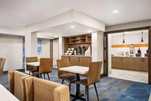 a restaurant with tables and chairs and a bar at La Quinta Inn Lexington-Horse Park in Lexington