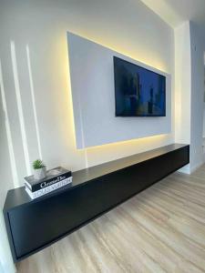 a living room with a television on a wall at RONI APARTMENTS -Near the historic city center -Family-friendly -Baby cots and toys available -Netflix -Convenient for sightseeing -Services available -Free parking with video surveillance in Prizren