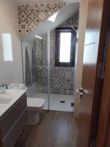 a bathroom with a toilet and a sink and a window at Casa Encarnación in Haría