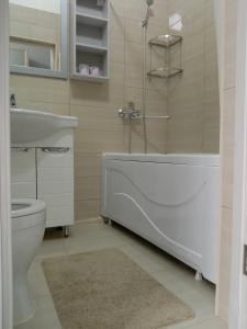 uma casa de banho com uma banheira, um WC e um lavatório. em Station Hostel em Atyrau