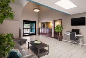 a living room with a couch and a table and a desk at Quality Inn Thomasville-Northpark in Thomasville