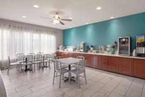 a dining room with a table and chairs and a kitchen at Quality Inn Thomasville-Northpark in Thomasville