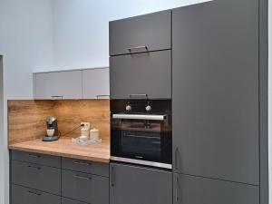 a kitchen with a stainless steel oven and cabinets at Ferienwohnung zum Peterbauer in Sachsenkam