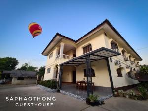 a hot air balloon flying over a house at Saphaothong guesthouse in Vang Vieng