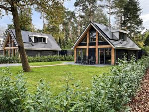 een huis met een gambrel dak bij Cosy energy friendly holiday home in a wooded area in Lochem in Lochem