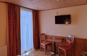 a room with a table and chairs and a television at Karnischer Hof in Sankt Stefan an der Gail