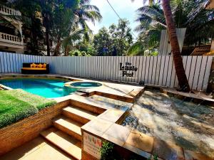 a swimming pool with a deck and a fence at WTF My House in Baga