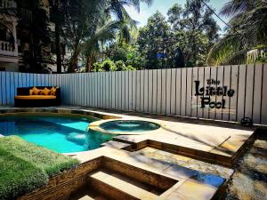 a swimming pool in a backyard with a fence at WTF My House in Baga