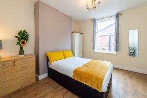 a bedroom with a bed and a dresser and a window at Cedar Room in Liverpool
